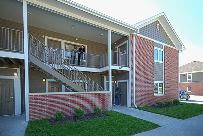 Two students standing on balcony of apartment building