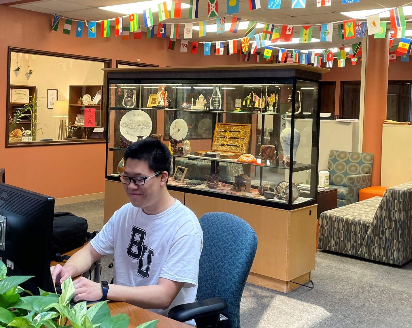 Male wearing BU shirt looking at computer
