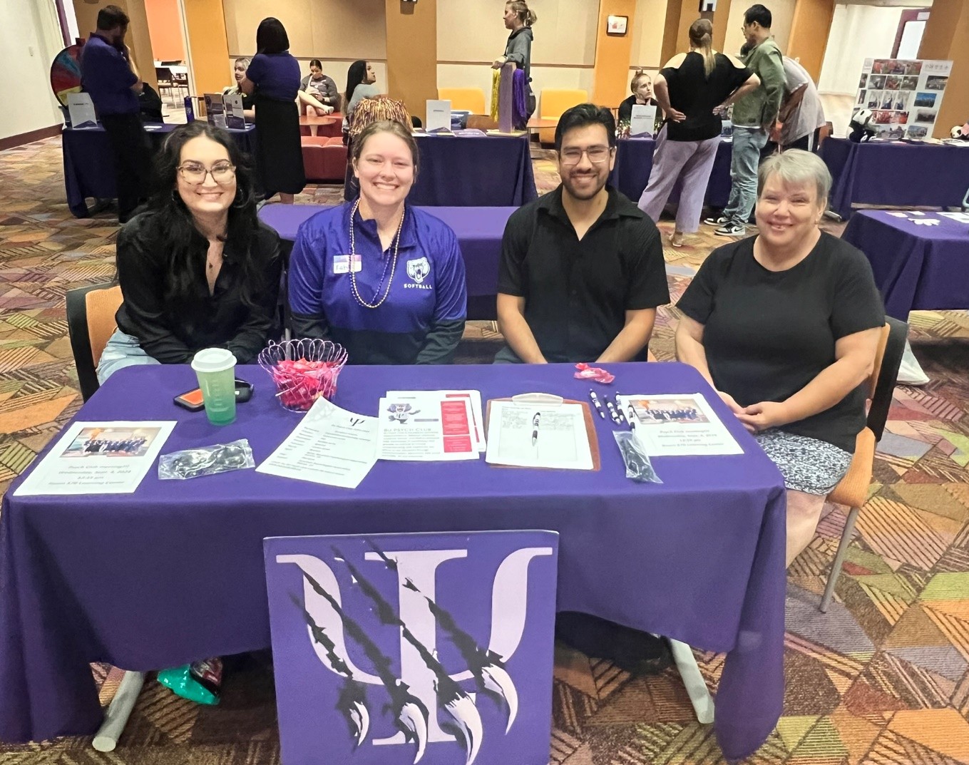 Four people sitting at a table with papers