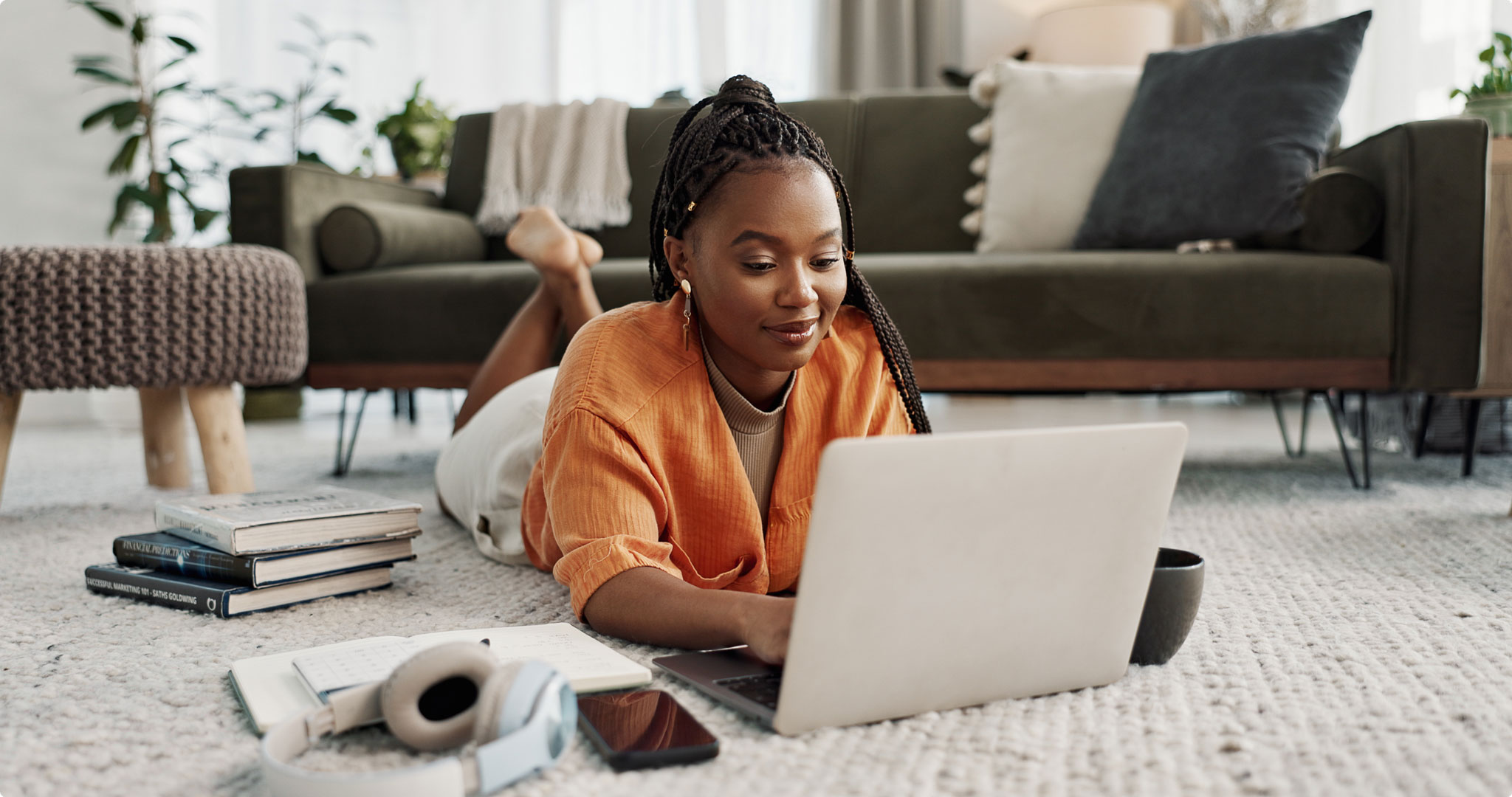 Young woman studying on the floor with laptop