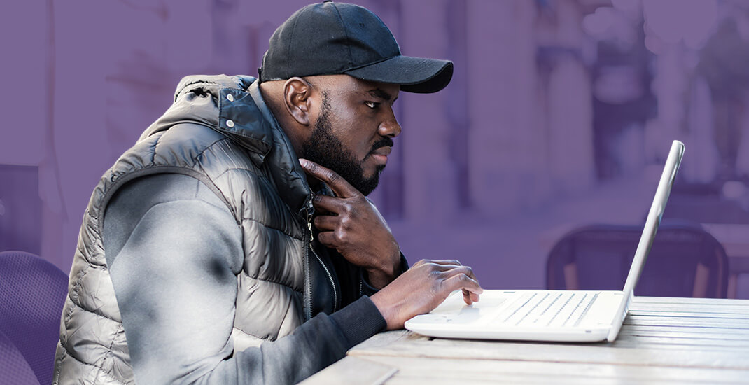 Man with hat working on computer