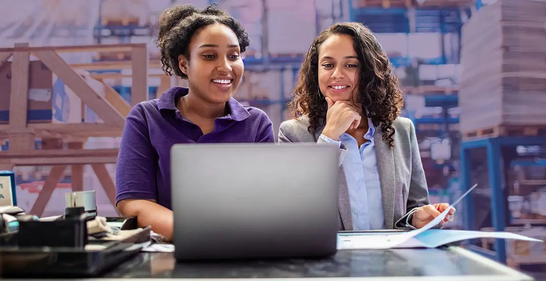 Two women looking at laptop smiling