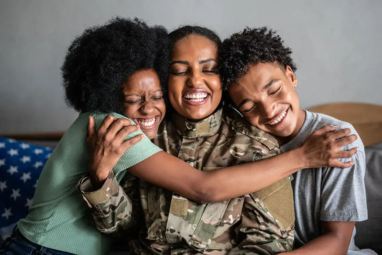 military mom with two kids hugging