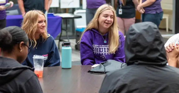 Students sitting at a table visiting.
