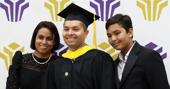 Student at graduation with family.